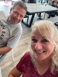 a man and woman smiling at a table in a restaurant