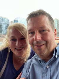 a man and woman taking a selfie in front of a building