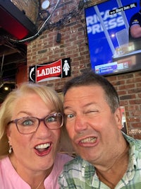 a man and woman posing for a selfie in a bar