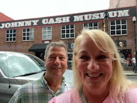 a man and woman standing in front of the johnny cash museum