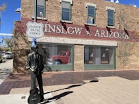 a statue of a man holding a guitar in front of a building