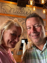 a man and woman posing for a selfie in a restaurant