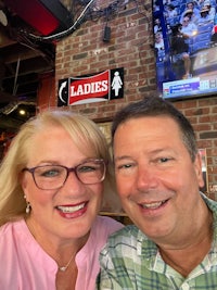 a man and woman posing for a selfie in a bar